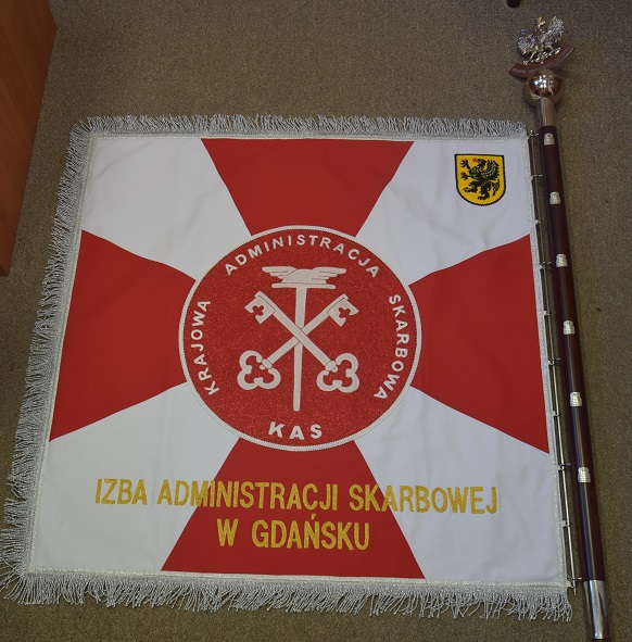 Sztandar ma biało-czerwone kolory i godło. Dwa skrzyżowane klucze na tle laski z uskrzydlonym kapeluszem Merkurego, na emblemacie w kształcie koła.