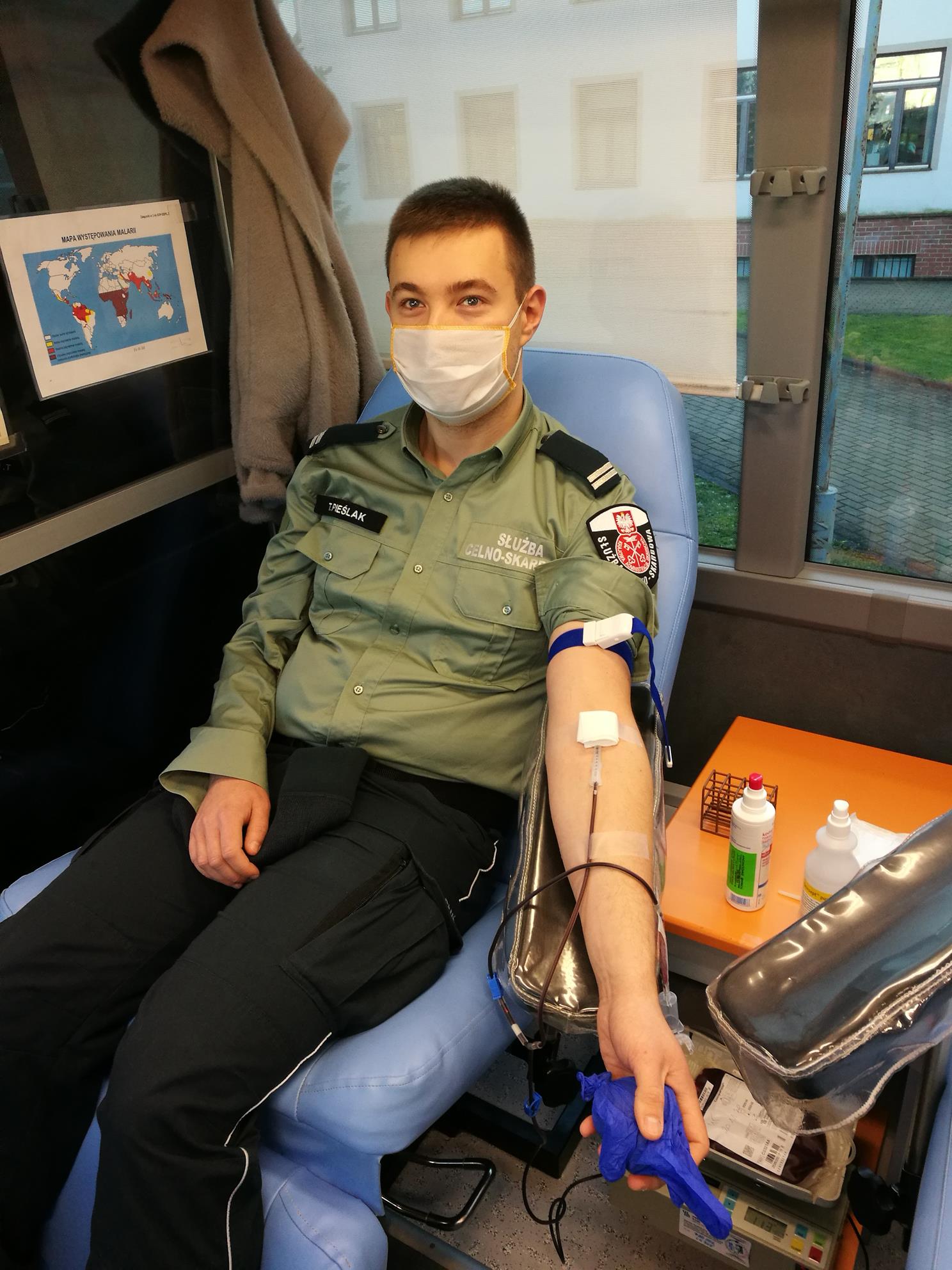 Funkcjonariusz oddaje krew w mobilnym punkcie poboru