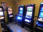 Kilka automatów do gier w ciemnym pomieszczeniu.