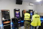 Pomieszczenie z nielegalnymi automatami do gier hazardowych.
Funkcjonariusze Służby Celno-Skarbowej i Policji stoją tyłem.