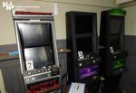 W jasnym pomieszczeniu znajdują się trzy automaty do gier. W lewym górnym rogu logo Krajowej Administracji Skarbowej.