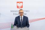 Wiceminister finansów Artur Soboń podczas konferencji prasowej na tle banera Ministerstwa Finansów