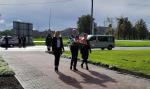 Dwie kobiety i mężczyzna idą w kierunku Pomnika Poległych Celników Polskich w Malborku- Kałdowie.
Mężczyzna trzyma w dłoniach wiązankę kwiatów.