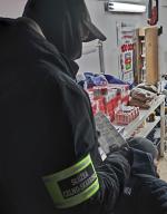 W pomieszczeniu funkcjonariusze zabezpieczają towar