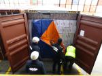 Funkcjonariusze celno- skarbowi oraz policja sprawdzają zawartość kontenera.